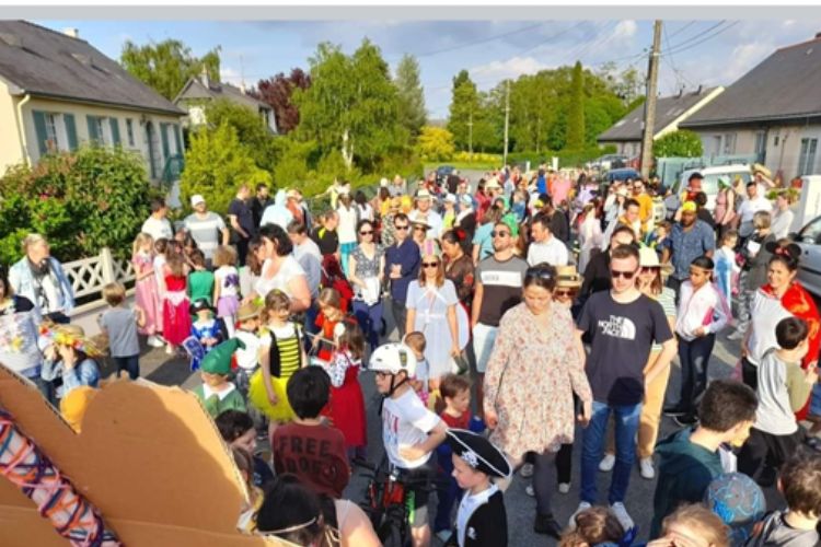 Parents et enfants déguisés suivent le char du carnaval de saint clement de la place